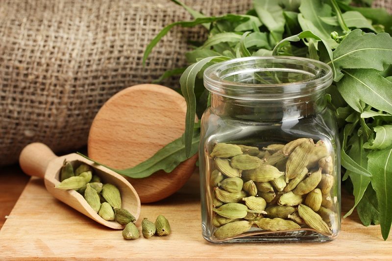 jar-of-green-cardamom-with-rocket-on-canvas-background-close-up